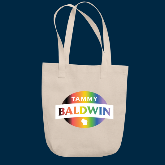 Canvas tote bag in a natural beige color with a rainbow Tammy Baldwin for Senate logo for Pride Month.